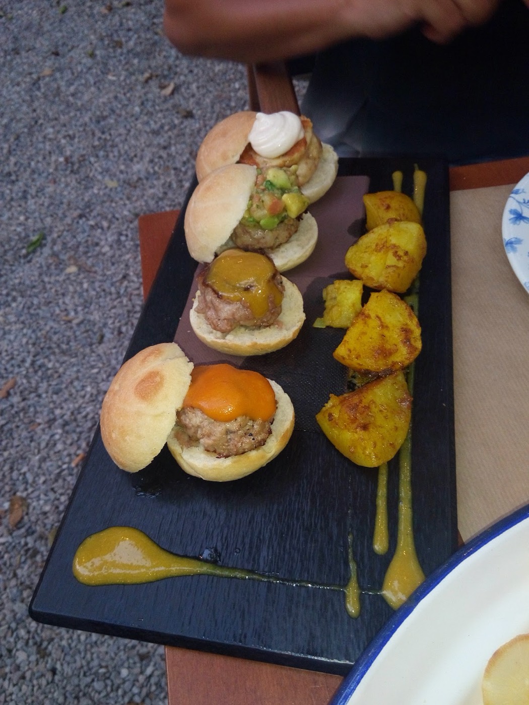 Mini burgers servidas sobre pizarra con patatas